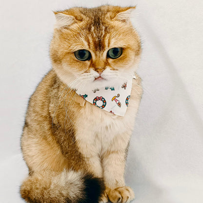 Brown cat wearing white Avery Christmas bandana, handmade holiday accessory for cats and small dogs.